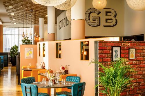 a restaurant with a table and chairs and a brick wall at Novotel London Greenwich in London