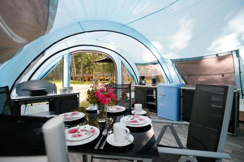 a tent with a table and a kitchen in it at Luxuswohnzelt ZELT UND SAND direkt am Strand in Dranske