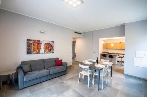 a living room with a couch and a table and chairs at GG12 Parma Comfort & Parking Suites in Parma