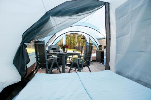 a tent with a table and chairs in it at Luxuswohnzelt ZELT UND SAND direkt am Strand in Dranske