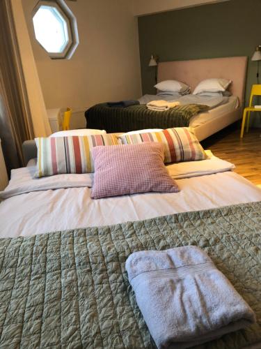 two beds with pillows on them in a room at Cosy apartment in the city center in Kemi