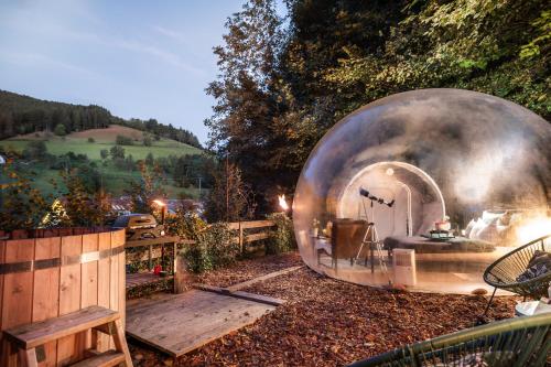 a metal domebedroom in a garden with a wooden fence at Bubble-Tent Elzach inklusive Hot Tube Badefass in Elzach