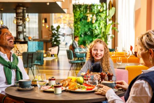 a group of people sitting around a table eating food at Novotel London Greenwich in London