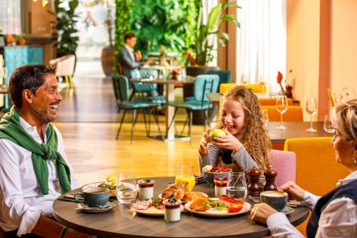 a group of people sitting around a table eating food at Novotel London Greenwich in London