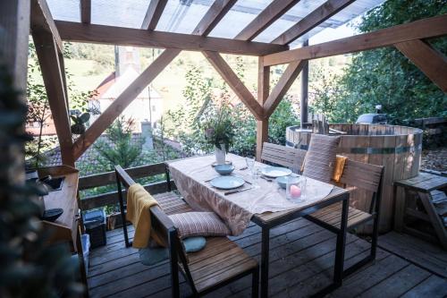 una terraza de madera con mesa y sillas. en Bubble-Tent Elzach inklusive Hot Tube Badefass, en Elzach