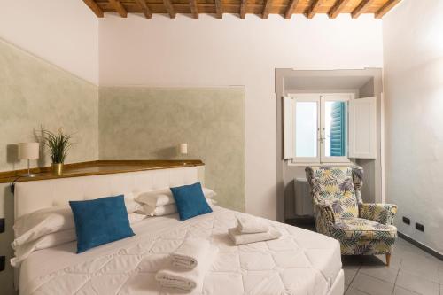 um quarto com uma cama branca e uma cadeira em Porta Rossa Dream em Florença