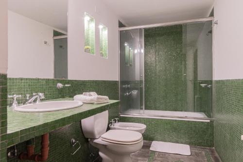 y baño con aseo, lavabo y ducha. en Fliphaus Soria 5100 - 4 Bd Pool Bbq Soho en Buenos Aires