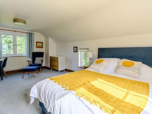 a large bedroom with a large bed with yellow pillows at The Gatehouse at Y Gwesty Bach in Jordanston