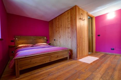 スコペッロにあるL'Ometto Bed&Breakfastの紫の壁とウッドフロアのベッドルーム1室
