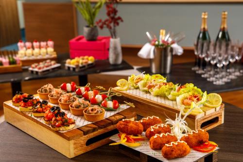 a table with several different types of food on it at Novotel London Greenwich in London