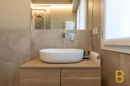 uma casa de banho com um grande lavatório branco sobre um balcão em BePlace Apartments in Primaticcio em Milão