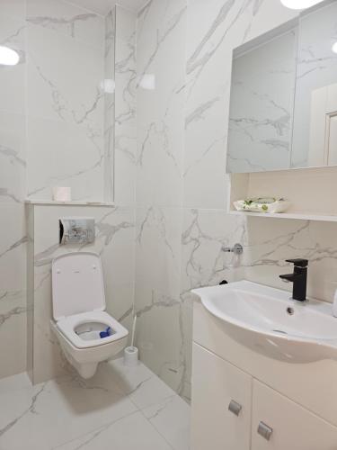 uma casa de banho branca com um WC e um lavatório em London Residence - Suceava City - em Suceava