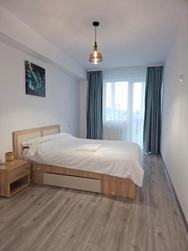 um quarto com uma cama grande e uma janela em London Residence - Suceava City - em Suceava
