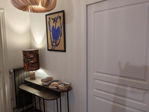 a room with a door and a table with a lamp at Villa Eliane - parking privé in Étretat