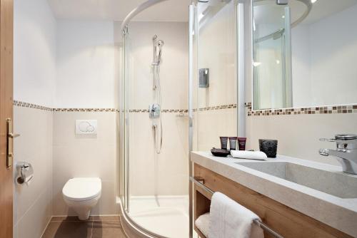 a bathroom with a shower and a toilet and a sink at Hotel Gletscherblick in Sankt Anton am Arlberg