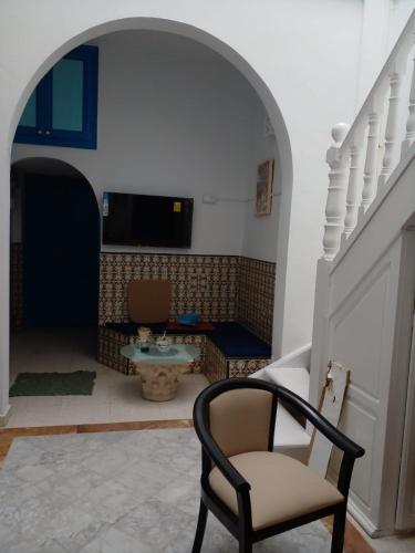 einen Torbogen mit einem Stuhl in einem Zimmer in der Unterkunft La maison 4 puits in Sidi Bou Saïd
