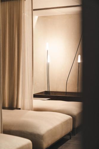 two beds in a room with two lights on the wall at Traumhotel Alpina Superior Adults only Hotel in Gerlos