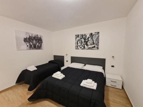 two beds in a bedroom with black and white at Monti Guest House Alghero in Alghero