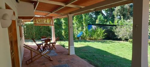 un porche cubierto con mesa y sillas en Casa completa/ familiar a 3km de playa el Arenal en Pedasí Town