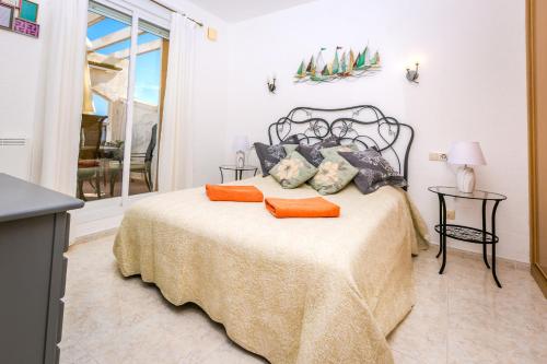 1 dormitorio con 1 cama con almohadas de color naranja en Panoramic Apartment, en Cumbre del Sol