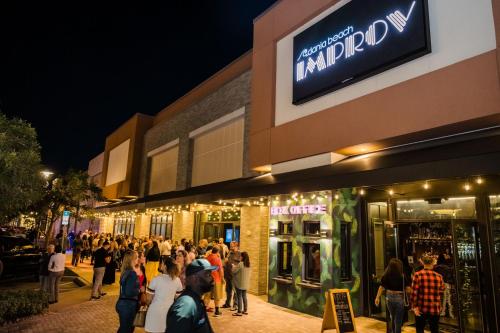 una multitud de personas de pie fuera de una tienda por la noche en Four Points by Sheraton Fort Lauderdale Airport - Dania Beach, en Dania Beach