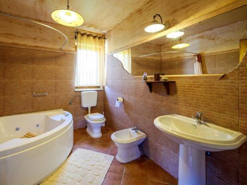 y baño con bañera, aseo y lavamanos. en Casa Barbici, en Rošini