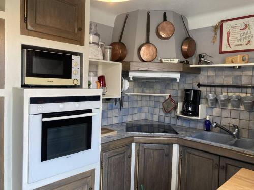 une cuisine avec un micro-ondes et une cuisinière four supérieur dans l'établissement Villa en front de mer, à Narbonne-Plage