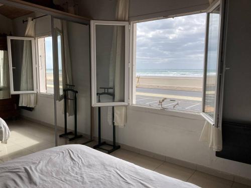 une chambre avec un lit et une vue sur la plage dans l'établissement Villa en front de mer, à Narbonne-Plage