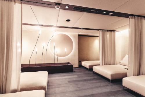 a hospital room with two beds and a mirror at Traumhotel Alpina Superior Adults only Hotel in Gerlos