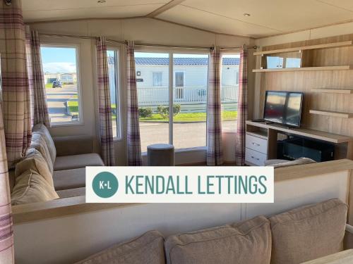 a living room with a couch and a television at Abi in Selsey