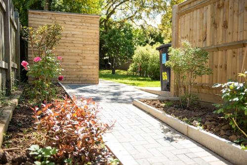 a garden with a brick walkway next to a fence at Walnut Flats-F2, 3-Bedroom with Garden & Patio - AC, Parking, Netflix, WIFI - Close to Oxford, Bicester & Blenheim Palace in Oxford