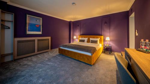 a bedroom with a bed and purple walls at Hotel Cocó in Timişoara