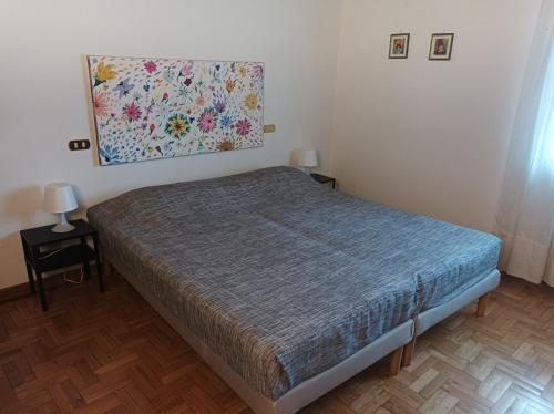 a bedroom with a bed with a painting on the wall at Villa Camelia Tuscany in Pescia