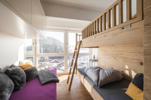 a room with a bunk bed and a large window at Dolomites Alpin Penthouse, 90qm, privat Sauna - privat Whirlpool in Mühlbach