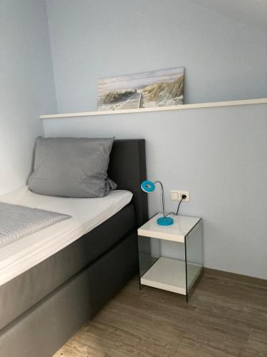a bedroom with a bed and a nightstand with a lamp at Das SinGold Hotel mit Highspeed WLAN und digitalem Schlüssel in Schwabmünchen