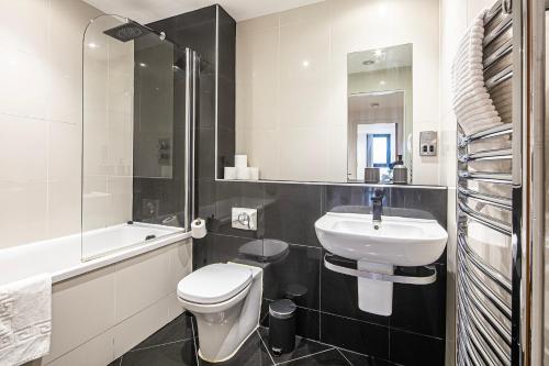 a white bathroom with a sink and a toilet at Stylish 2 Bed City Centre Apartment with Sofa Bed - FREE Parking, Coffee Machine, Netflix & Alexa in Sheffield
