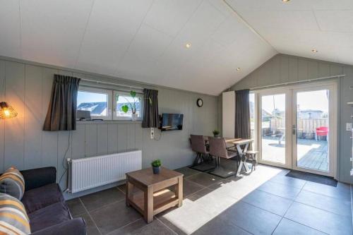 a living room with a couch and a table at NEW! Strandhuis 't Koepeltje aan zee! in Callantsoog
