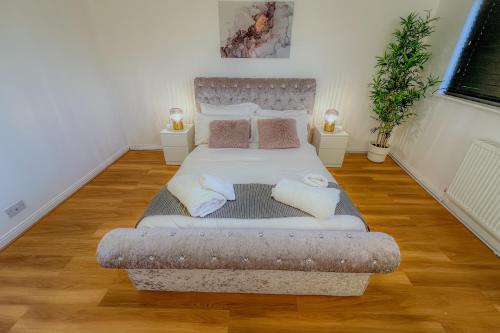 Un dormitorio con una cama grande con almohadas. en Deluxe 2 Bed Apartment- Near Heathrow, Legoland, Windsor Slough en Slough