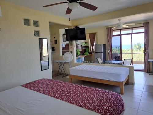 a bedroom with two beds and a living room at Posada Nautica in Mazunte