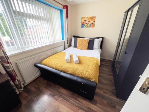 a bedroom with a bed with two slippers on it at 2 Bedroom Tudor House Pristine and Comfortable Close to Birmingham City Hospital in Birmingham