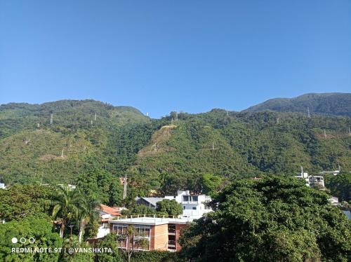 Blick auf einen Berg mit Häusern und Bäumen in der Unterkunft The Warren @Torreavila in Caracas