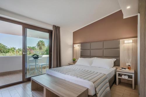 a bedroom with a large bed and a balcony at Vascellero Club Resort in Cariati