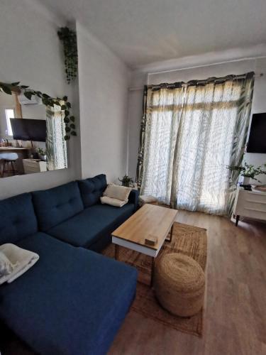 un salon avec un canapé bleu et une table dans l'établissement T3 avec terrasse à 200 mètres de la mer, à Canet
