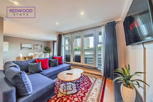 a living room with a blue couch and a table at Spacious 2 Bed 2 Bath Apartment, Near Train Station, FREE Parking By REDWOOD STAYS in Woking