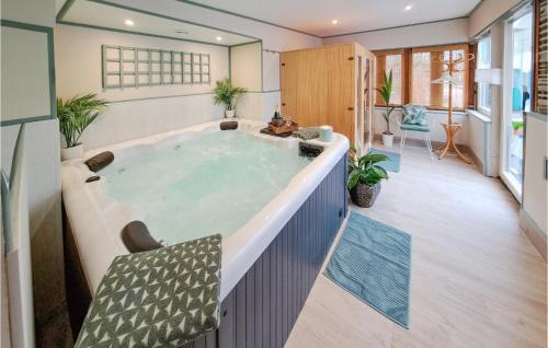 bañera de hidromasaje en el medio de una habitación en Beautiful Home In Thierville With Outdoor Swimming Pool 