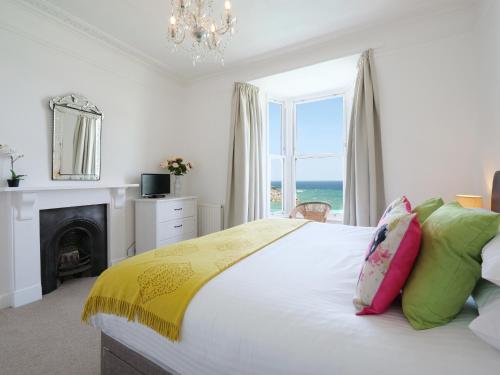 - une chambre avec un lit et une vue sur l'océan dans l'établissement Waves End, à St Ives