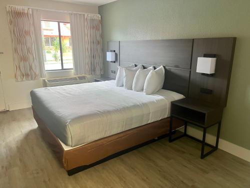 a bedroom with a large bed and a window at Quality Inn & Suites Orlando East - UCF Area in Orlando