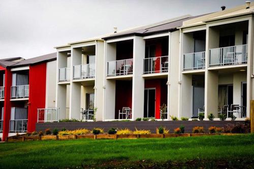 a large apartment building with red and white at City Golf Club Motel in Toowoomba