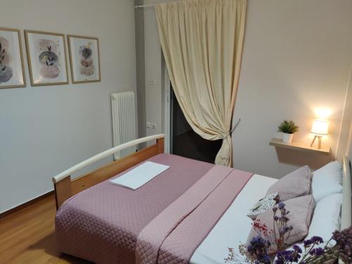 sypialnia z łóżkiem z fioletowym kocem i oknem w obiekcie Beach House w Chalkidzie