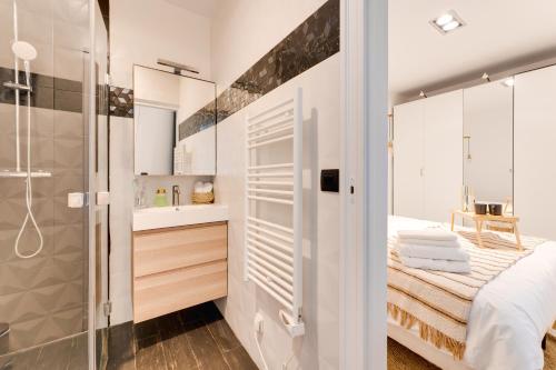 uma casa de banho branca com um chuveiro e uma cama em PorteMaillot & La Défense 4 Bedroom 10 people em Neuilly-sur-Seine